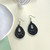 Small black wooden cut out teardrop earrings on hooks