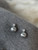 Grey metallic sphere dangling from diamante stud earrings