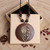 Wooden pendant with antique look leaf on brown cord