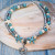 Two layer anklet with grey and turquoise beads, starfish and three dolphin charm
