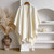 Women's warm textured knit cape with tassels white