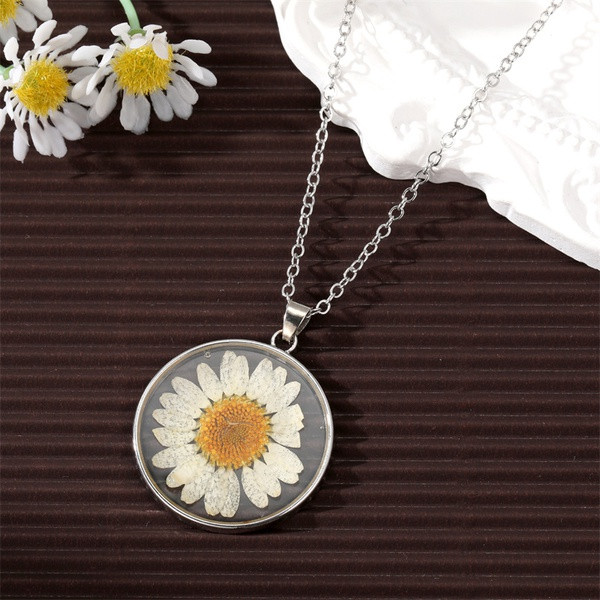 Dried pressed flower in resin pendant necklace with silver coloured surround on chain