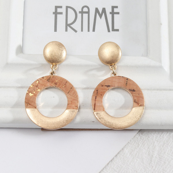 old looking, distressed wood finish on matte gold circle earrings hung from stud on posts