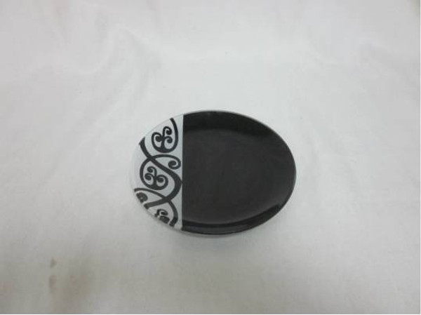 Round glass plate with black and white Maori design (measures approx 8" across)