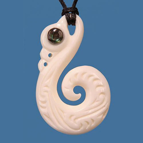 Hand carved bone Manaia with koru pendant