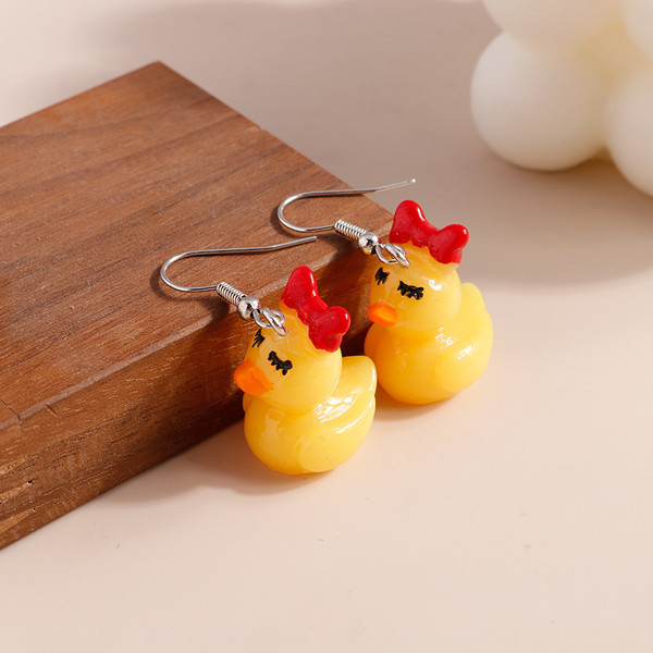 Yellow duck earrings with red bow and long eyelashes