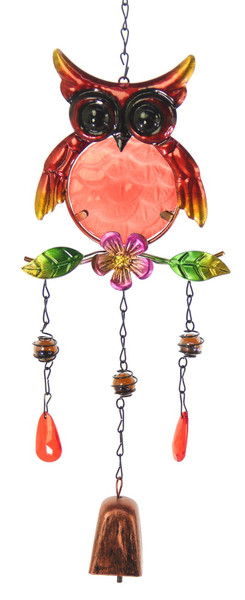 Red owl sitting on a branch with bell windchime