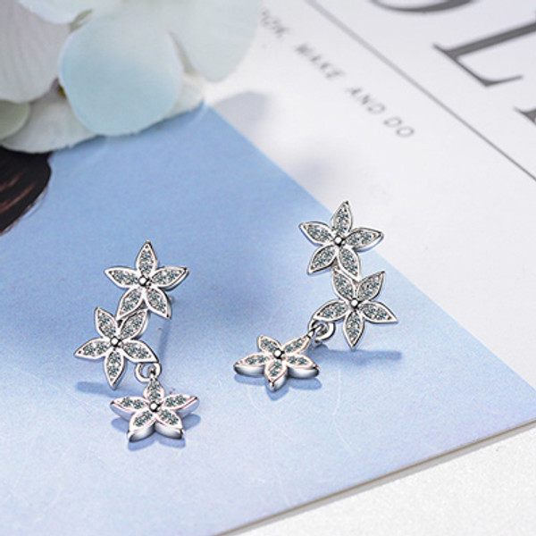 Silver coloured earrings with 3 flowers and diamante detail on posts