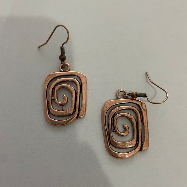 Rose gold coloured koru style spiral earrings on hooks