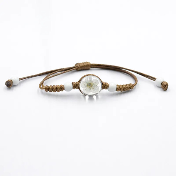 Bracelet with white dried flower in a glass ball on brown cord