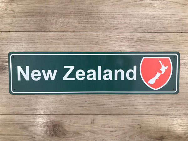 Green tin New Zealand road-style sign with a New Zealand map