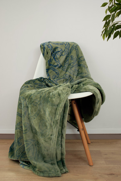 Kowhaiwhai design in blue on warm fleece green blanket