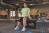 Actimove Sports Edition Knee Support - with woman wearing it while lifting weights