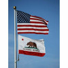 The flag of California flies below the American flag. The flag of California features a grizzly bear over a white background with a red star in its top left corner. Under the bear is text reading “California Republic,” under which is a red stripe.