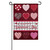 A pink and red garden flag picturing nine hearts with different patterns. On the lower half of the flag the text "happy Valentine's day" is written.