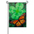 A garden flag depicting a large green four-leaf clover with a monarch butterfly.