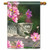This curious kitty flag has a gray kitten curiously looking at a pink flower with other flowers in the distance.