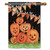 A black house flag picturing a stack of six smiling jack-o-lanterns beneath a row of pennant flags. 