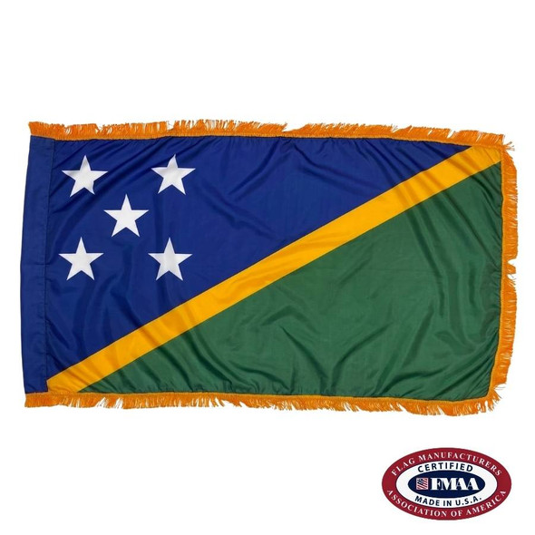 The indoor Solomon Islands flag has gold fringe around 2 blue & green triangles separated by a yellow line with 5 stars in the upper left. FMAA Certified Made in America seal.