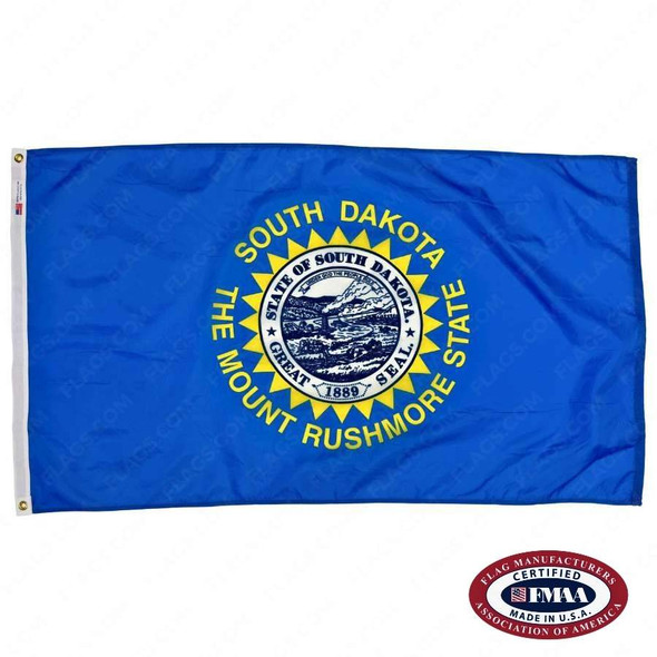 The blue South Dakota flag has a seal in the center, encircled by a serrated border & the text “South Dakota The Mount Rushmore State.” FMAA Certified Made in America seal.