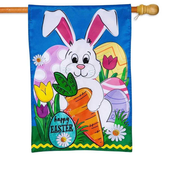 A Happy Easter Bunny and Carrot Garden Flag depicting a large white rabbit holding an orange carrot in front of Easter eggs.