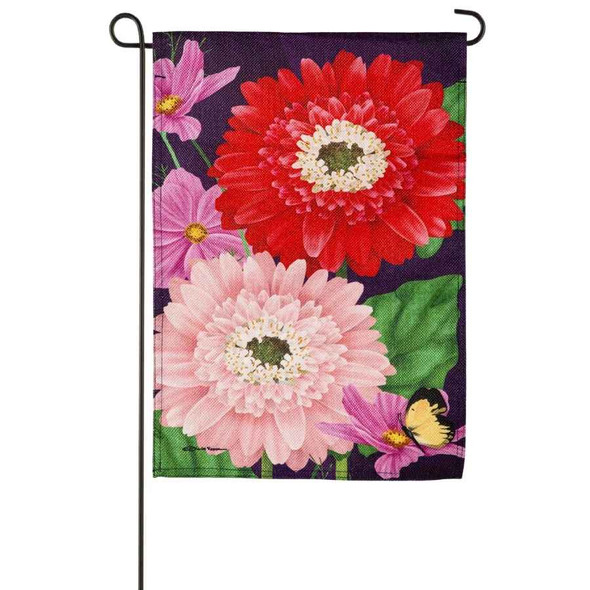A Blooming Gerbera Garden Flag depicting two large Gerbera daisies in red and pink on a dark blue background.