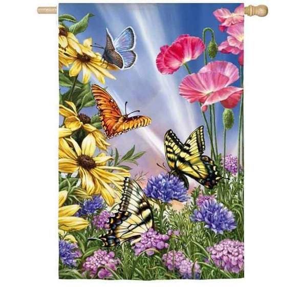 Among the yellow, pink and purple flowers are zebra and monarch butterflies.  The blue sky with the sun's rays is in the background.