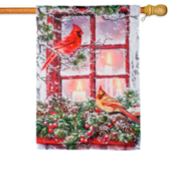A house flag depicting two cardinals perched on holly outside a window lit by candles. 