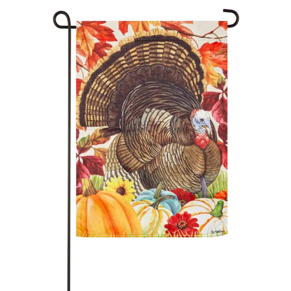 A November Turkey Suede Garden Flag depicting a large turkey surrounded by gourds and leaves.