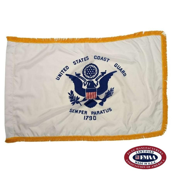 The indoor Coast Guard flag has a white field surrounded by 3 borders of gold fringe. In the center of the flag is a seal with a bald eagle. FMAA Certified Seal.
