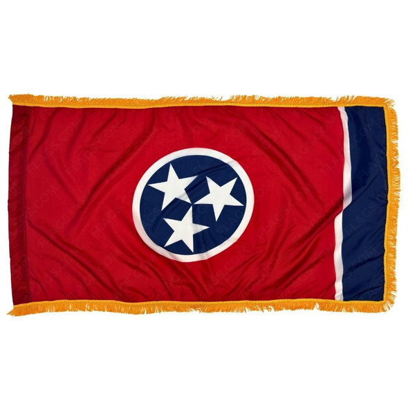 The indoor Tennessee flag has 3 sides of gold fringe around the red field. On the right is a blue bar & in the center is a circle with 3 stars.