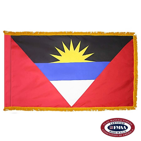 The indoor Antigua & Barbuda flag has 3 sides of gold fringe around a red field with an upside-down multicolor triangle depicting a rising sun. FMAA Certified Made in America seal.