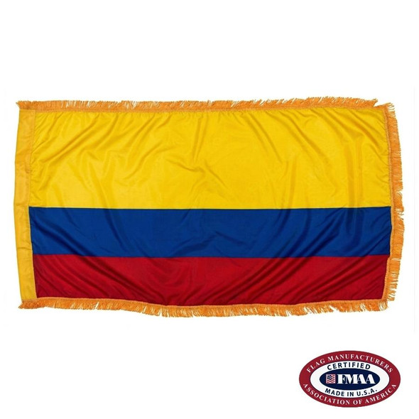 The indoor Colombia flag has 3 sides of gold fringe around a horizontal tricolor of wide yellow and narrower blue and red stripes. FMAA Certified Made in America seal.