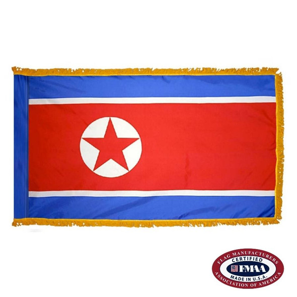 The indoor North Korea flag has 3 sides of fringe around five blue, white, & a wide red stripe. On the left is a red star in a white circle. FMAA Certified Made in America seal.