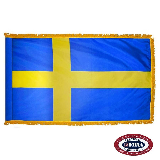 The indoor Sweden flag has 3 sides of gold fringe around a blue field with a yellow Nordic cross pointing to the left. FMAA Certified Made in America seal.