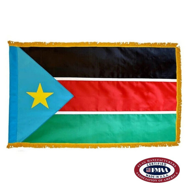 The indoor South Sudan flag has 3 sides of gold fringe around a black, red, and green tricolor with a blue triangle and star on the left. FMAA Certified Made in America seal.