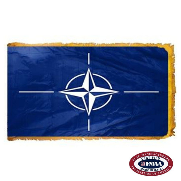 The indoor NATO flag has 3 sides of gold fringe around a dark blue field with a white compass rose in the center. FMAA Certified Made in America seal.