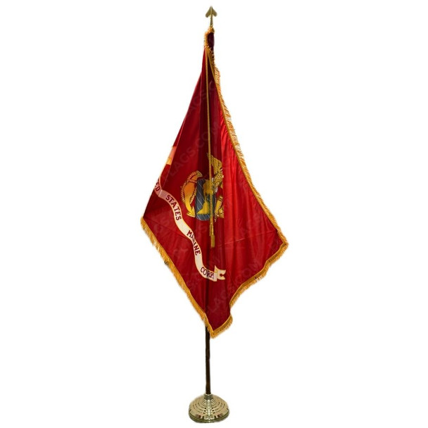 The flag of the U.S. Marine Corps features a centered gold eagle, gray globe, and gold anchor, the Corps’ traditional logo, with a streaming banner beneath reading “United States Marine Corps” all over scarlet background. It hangs at rest, attached to an ornate golden flagpole. The flag’s sides not attached to the flagpole have golden fringes. A decorative gold cord and tassel sit at the top of the flagpole.
