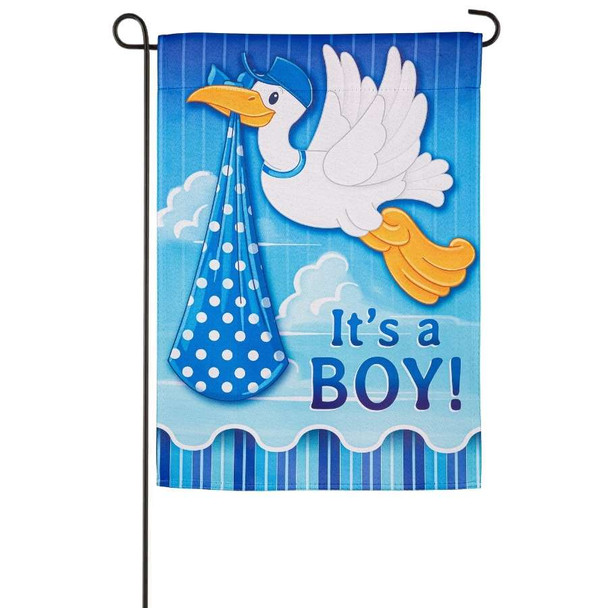 A blue garden flag depicting a white stork carrying a blue bundle above the text "It's a Boy!".