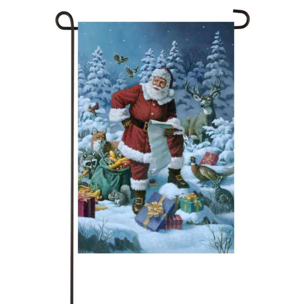 A garden flag picturing Santa holding a long list in the middle of a snowy forest. He is surrounded by presents and animals such as deer, foxes, and pheasants.