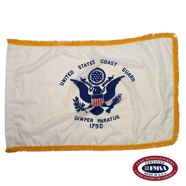 The indoor Coast Guard flag has a white field surrounded by 3 borders of gold fringe. In the center of the flag is a seal with a bald eagle. FMAA Certified Seal.