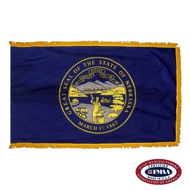 The indoor Nebraska flag has 3 sides of gold fringe around the dark blue field. In the center is the yellow state seal, depicting a blacksmith. FMAA Certified Made in America seal.
