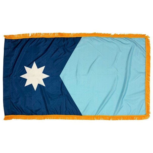 The indoor Minnesota flag has 3 borders of gold fringe around two dark and light blue fields. On the left is an 8-pointed star.