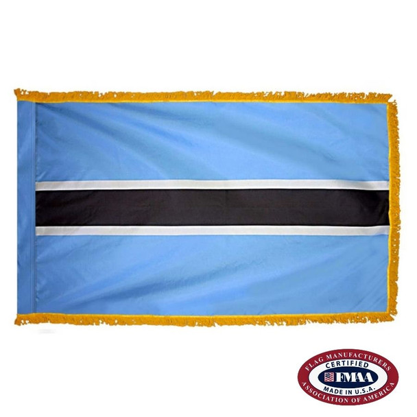 The indoor Botswana flag has 3 sides of gold fringe around 5 horizontal stripes of thick blue, thin white, black, white, and blue. FMAA Certified Made in America seal.