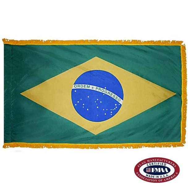 The indoor Brazil flag has 3 sides of gold fringe around a dark green field, in the center of which is a yellow diamond and blue circle. FMAA Certified Made in America seal.