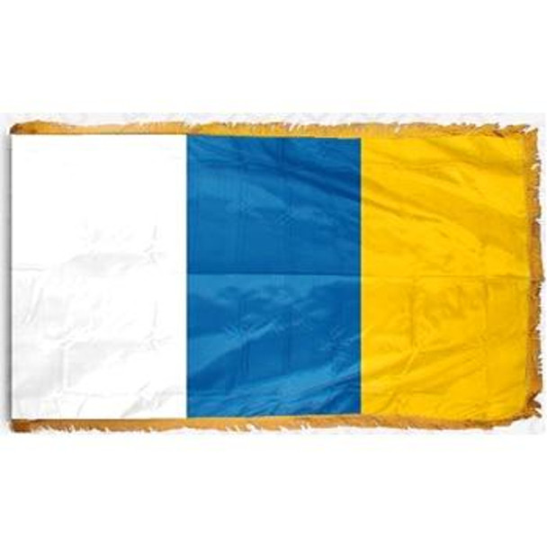 The indoor Canary Islands flag has 3 sides of gold fringe around a white, blue, and yellow tricolor.