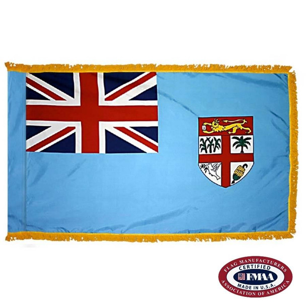 The indoor Fiji flag has 3 sides of gold fringe around a light blue field with a Union Jack in the canton and a seal on the right. FMAA Certified Made in America seal.