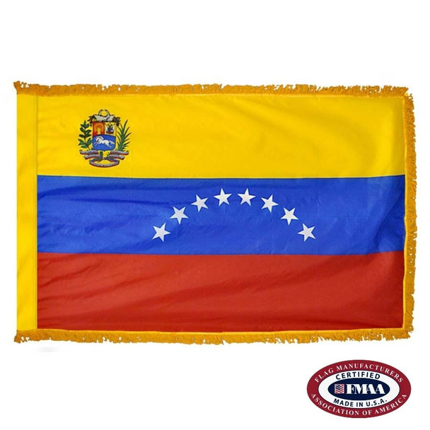 The indoor Venezuela flag has 3 sides of gold fringe around a yellow, blue, and red tricolor with white stars in the center. FMAA Certified Made in America seal.