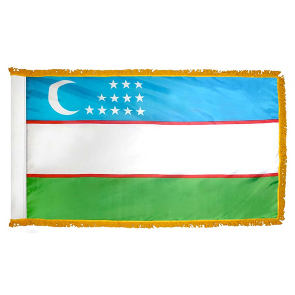 The indoor Uzbekistan flag has 3 sides of gold fringe around a blue, white, and green tricolor. At the top is a white crescent and 12 stars.