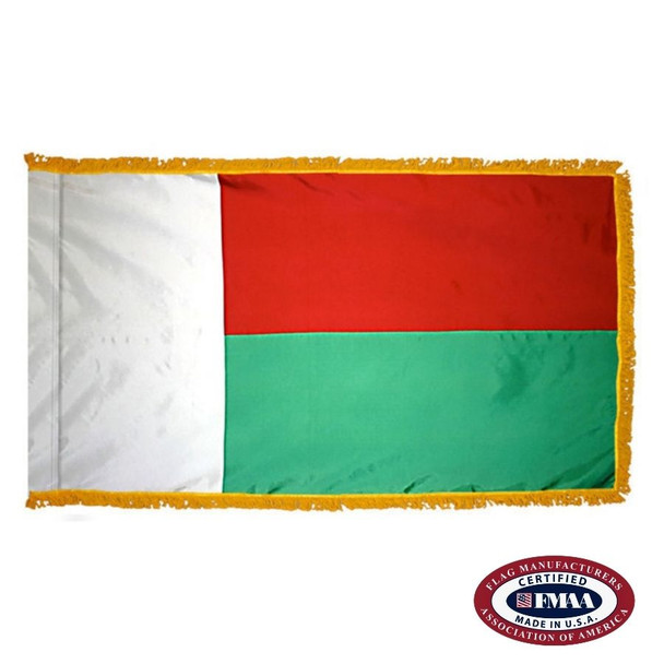 The indoor Madagascar flag has 3 sides of gold fringe around two horizontal red and green stripes. On the left is a vertical white band. FMAA Certified Made in America seal.